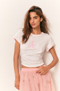 White graphic T-shirt with pink logo, short sleeves, crew neck