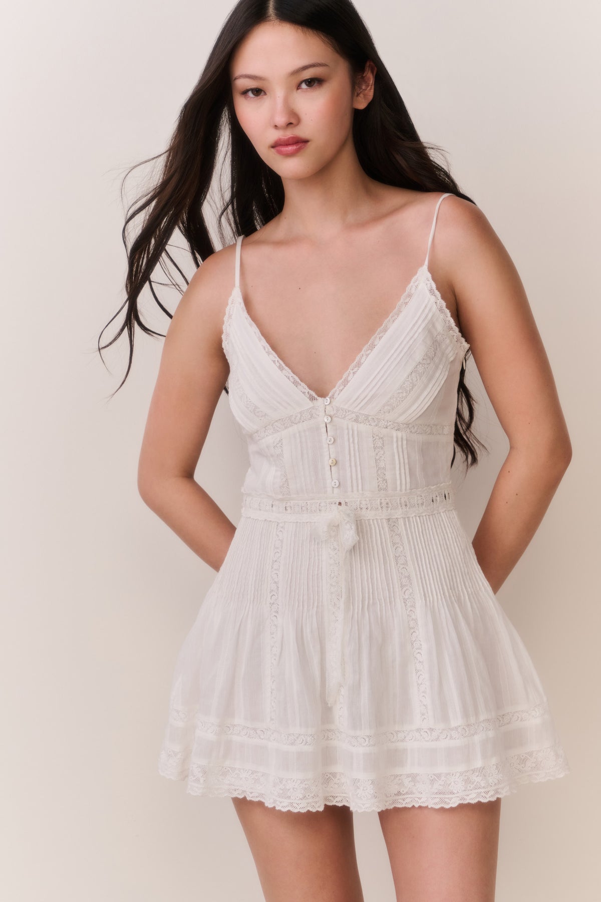 White cotton Victorian mini dress with spaghetti straps, lace trim, tiered skirt, front view