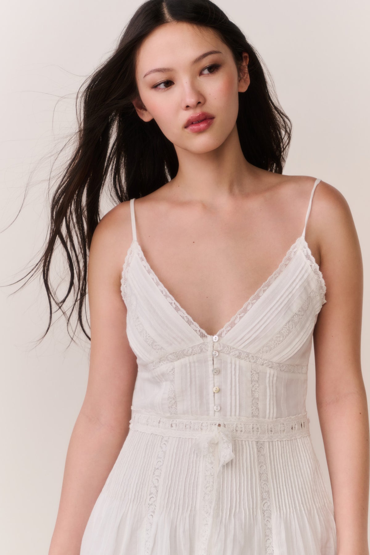 White cotton Victorian mini dress with V-neck, lace-trimmed bodice, button placket, close-up