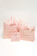 Pink patterned gift bags set with ribbon handles and a small matching tote