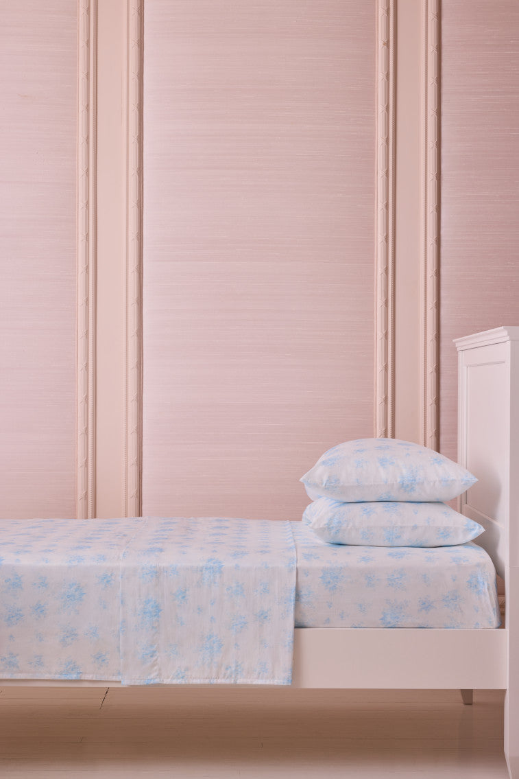 Light blue floral sheet set with pillowcases on a bed, folded view