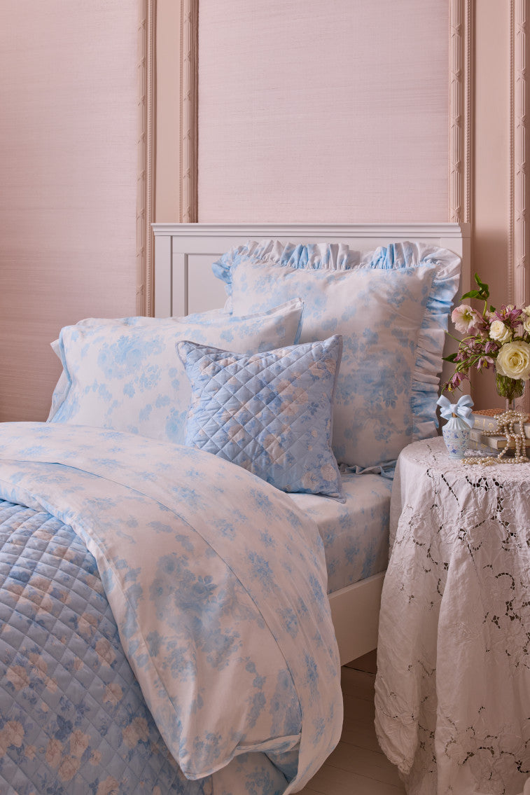Blue floral cotton sateen sheet set with matching shams on a bed