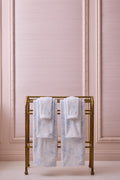 Light blue cotton wash cloths folded on a gold rack