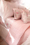 Floral cotton sateen sheet set in soft pink with scattered rose prints and ruffled pillows