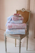 Cotton bath towel set, pink and light blue floral bow prints, folded stacks.