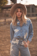 Woman wearing a denim outfit with floral embroidery in an outdoor setting