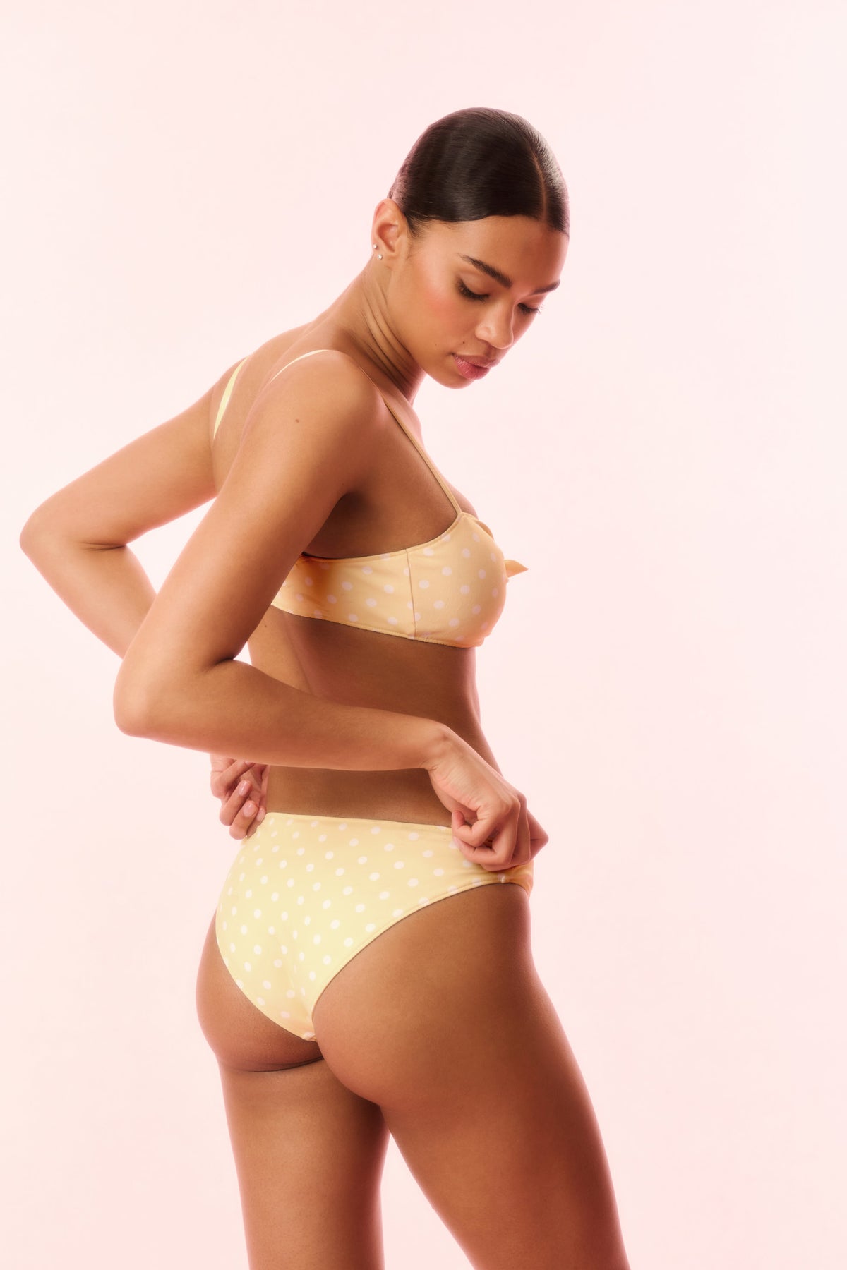 Marigold yellow polka-dot bikini set with twist-front bandeau top and high-cut briefs