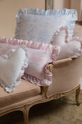 Pink and light blue ruffle throw pillows with gathered edges on a sofa