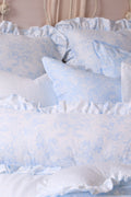 Light blue floral ruffle throw pillows with gathered edge trim in layered arrangement