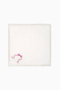 White embroidered napkin with pink motif at corner and lace-trim border