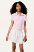 Light pink short-sleeve polo shirt with collar, paired with white tiered skirt