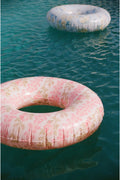 Close-up pink floral pool float, circular ring with visible texture