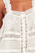 White cotton camisole top with lace trim, scalloped edges, and front button placket