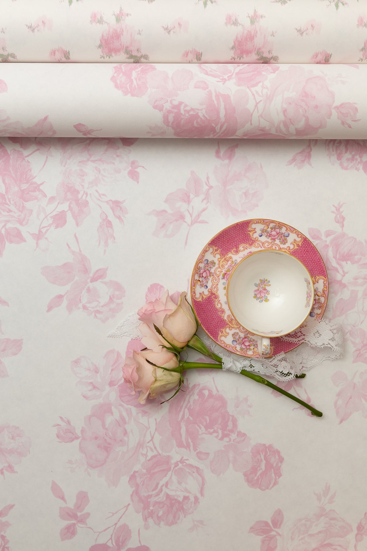 Pink floral rosette wallpaper pattern with small blossoms on pale background