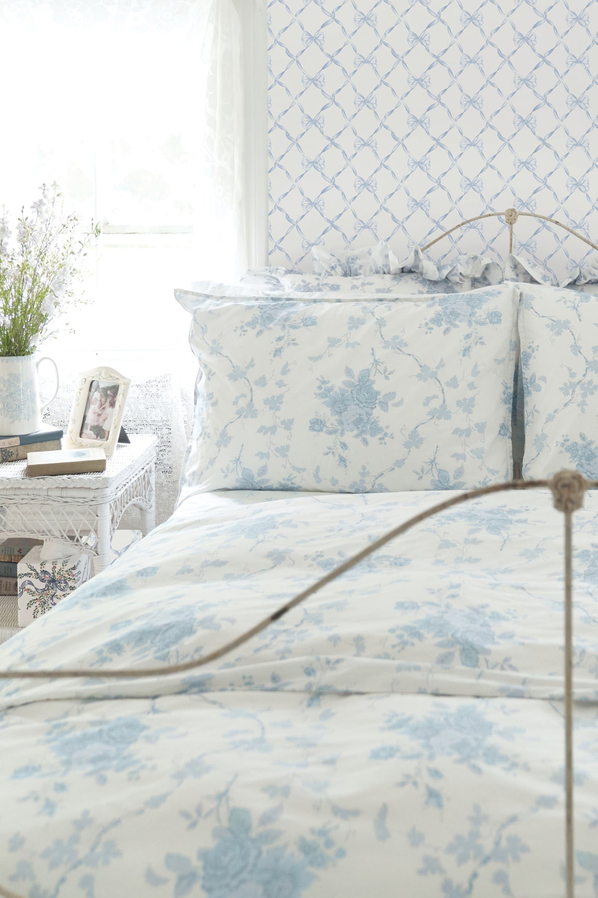 Powder blue bow trellis wallpaper with repeating chain-link ribbon knots.