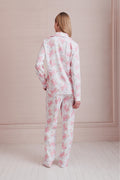 Women's long-sleeve pajama set in pink-and-white bow print, back view of top and pants