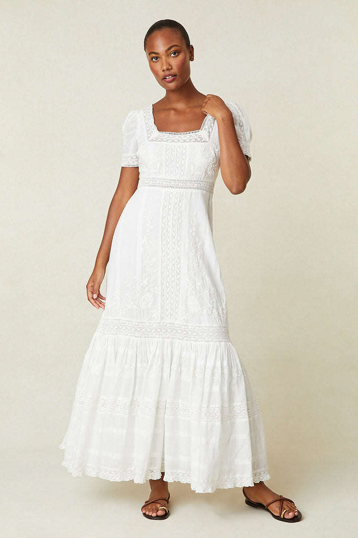 White Victorian-style maxi dress with square neckline, puff sleeves, and tiered skirt