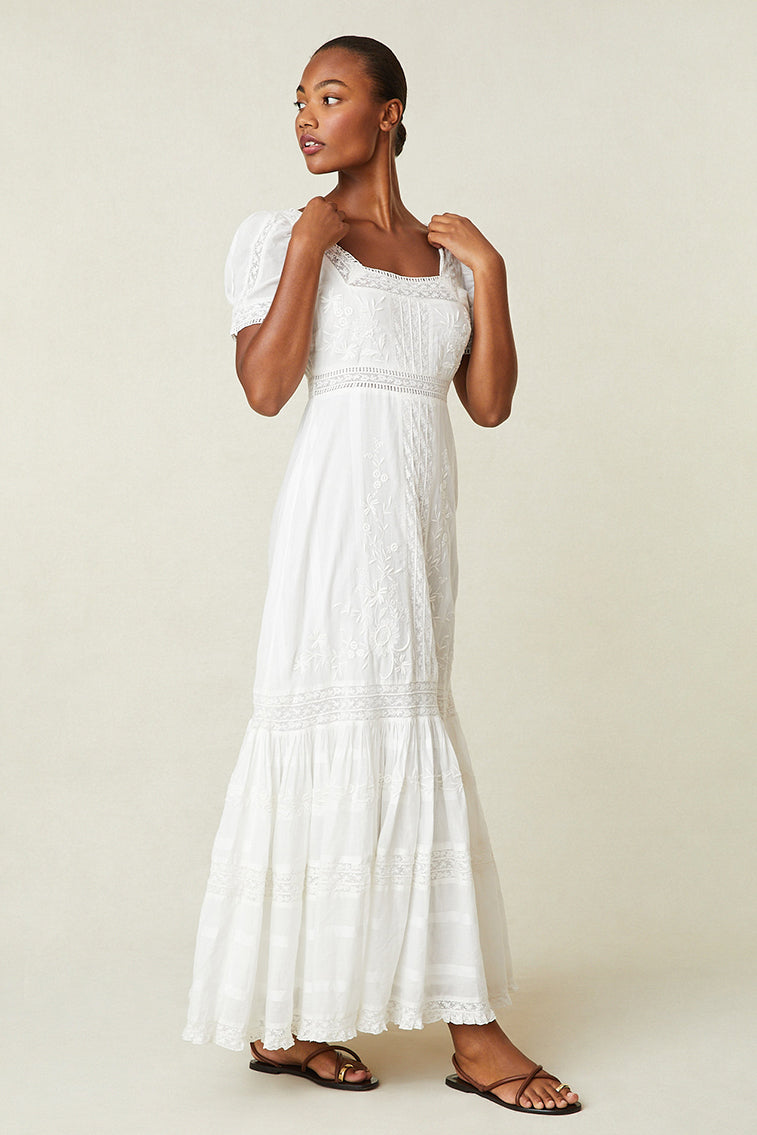 White Victorian maxi dress with textured bodice, square neck, puff sleeves, tiered hem