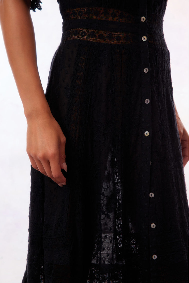 Black maxi dress close-up: button front details and textured fabric paneling