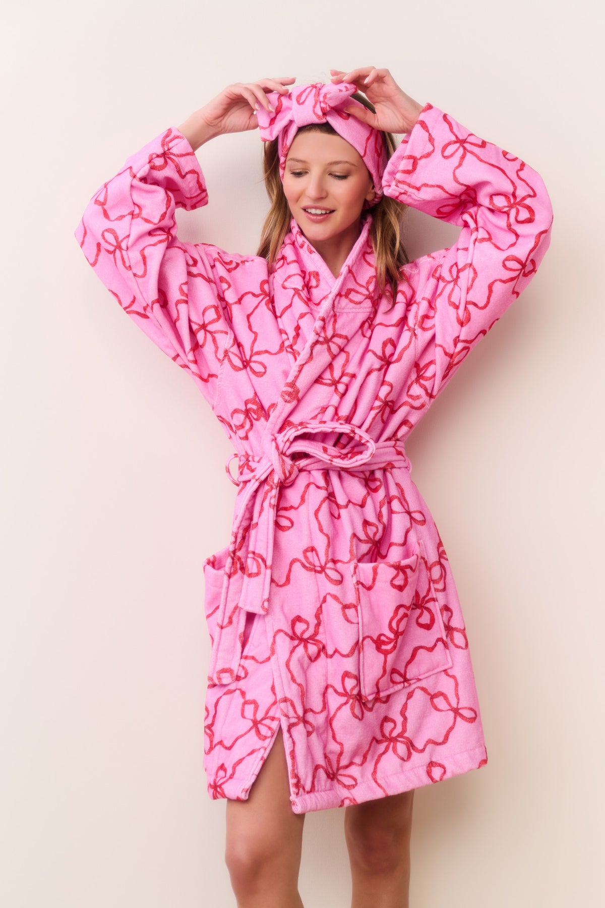 Pink cotton bath robe with bow-like print, ruffled cuffs and waist tie