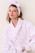 Pink floral bow headband worn on head with gathered ruffle and tied knot