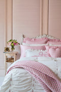 Pink diamond-quilted quilt with ruffled trim and light floral print