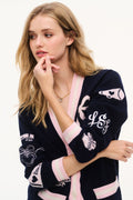Navy wool varsity cardigan close-up with pink V-neck trim and embroidered sleeves