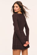 Dark brown pointelle mini dress with long sleeves and tiered ruffle skirt, back angle.