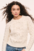 Ivory textured cable-knit sweater with crew neckline and long sleeves