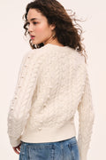 Ivory cable-knit sweater with raised stitch pattern and long sleeves