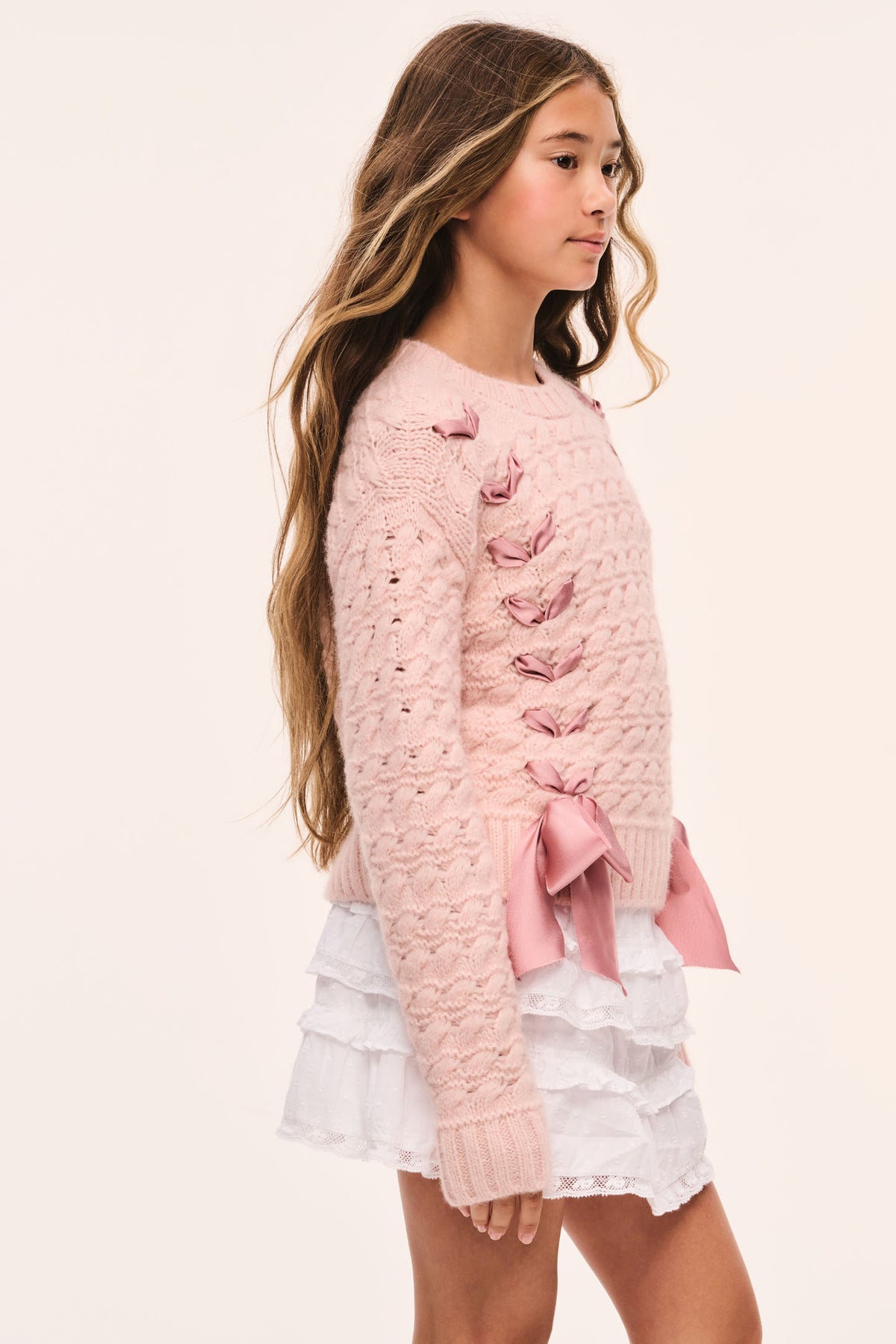 Tween pink textured knit pullover side view with ribbon threaded through and bow at hem