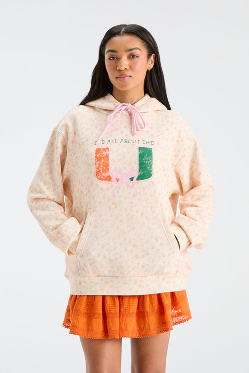 Cream patterned Nacova hoodie with drawstring hood and multicolor graphic text.