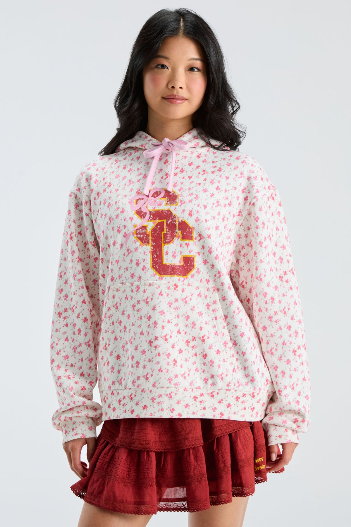 Pink floral pullover hoodie with hood and pink drawstring, gold-and-navy front graphic
