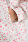 Pink floral hoodie close-up with kangaroo pocket and pink drawstring ends