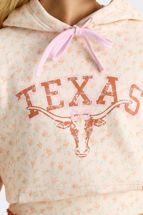 Pink floral-print hoodie with hood tie ribbon and large Texas logo graphic on chest