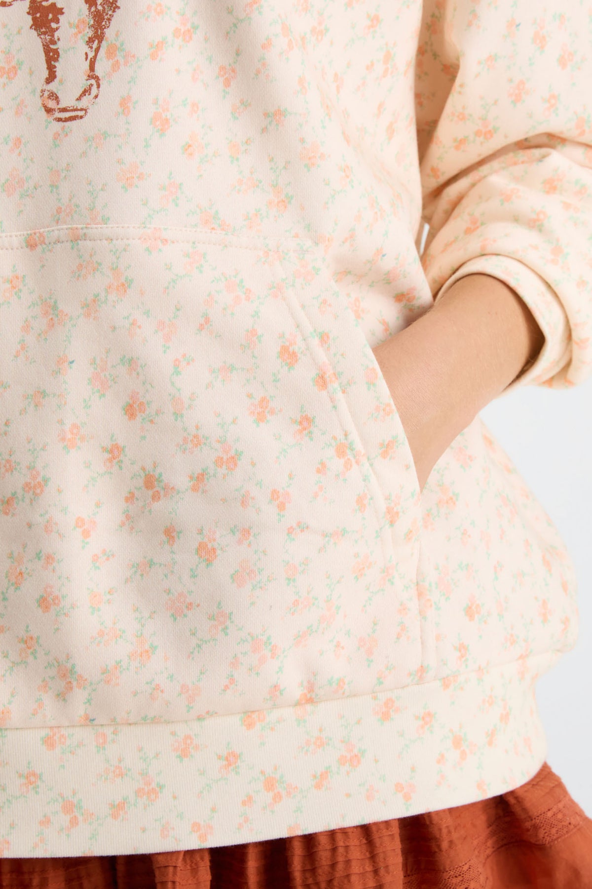Cream patterned Nacova hoodie sleeve detail with drawstring hood and kangaroo pocket.