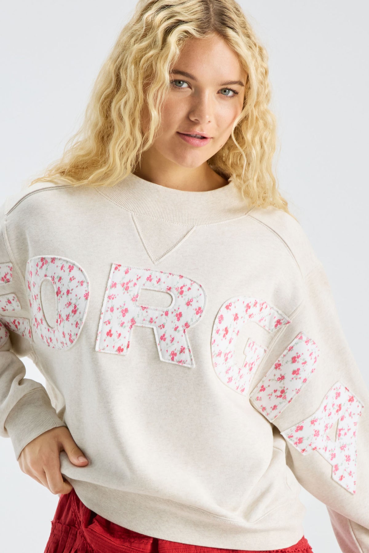 Cream mockneck crew sweatshirt with large pastel “LOVE” applique on chest