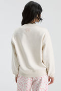 Cream mockneck crew sweatshirt with small back logo and pink floral letter graphic