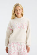 Cream mockneck crew sweatshirt with pink floral “U S C” letter graphic and long sleeves
