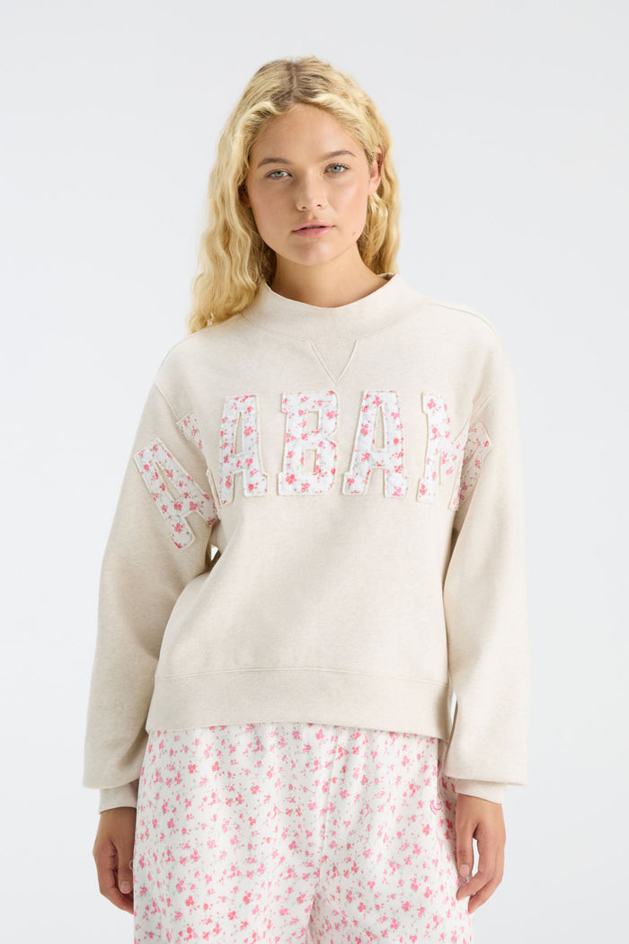 Cream mockneck crew sweatshirt with pink floral “U S C” letter graphic and long sleeves