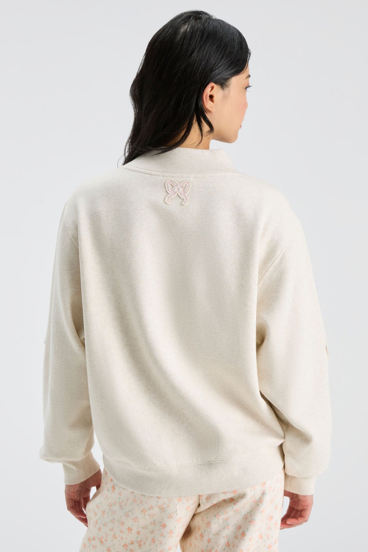 Cream mockneck sweatshirt shown from back with small "LOVE" detail
