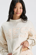 Cream mockneck sweatshirt close-up with multicolor "LOVE" lettering