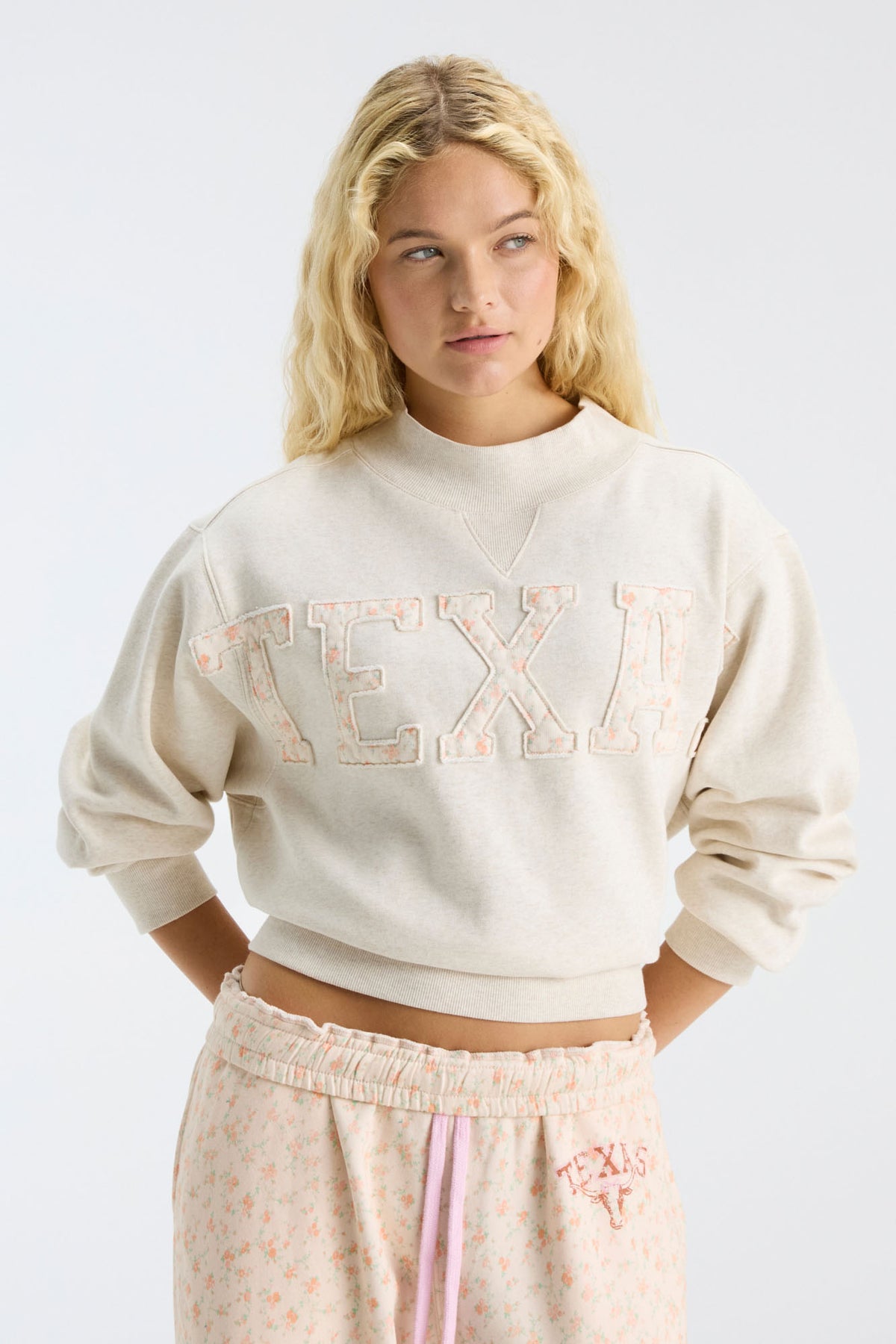 Cream mockneck sweatshirt with large "LOVE" graphic and relaxed cropped fit