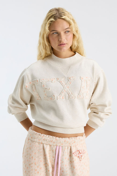 Cream mockneck sweatshirt with large "LOVE" graphic and relaxed cropped fit