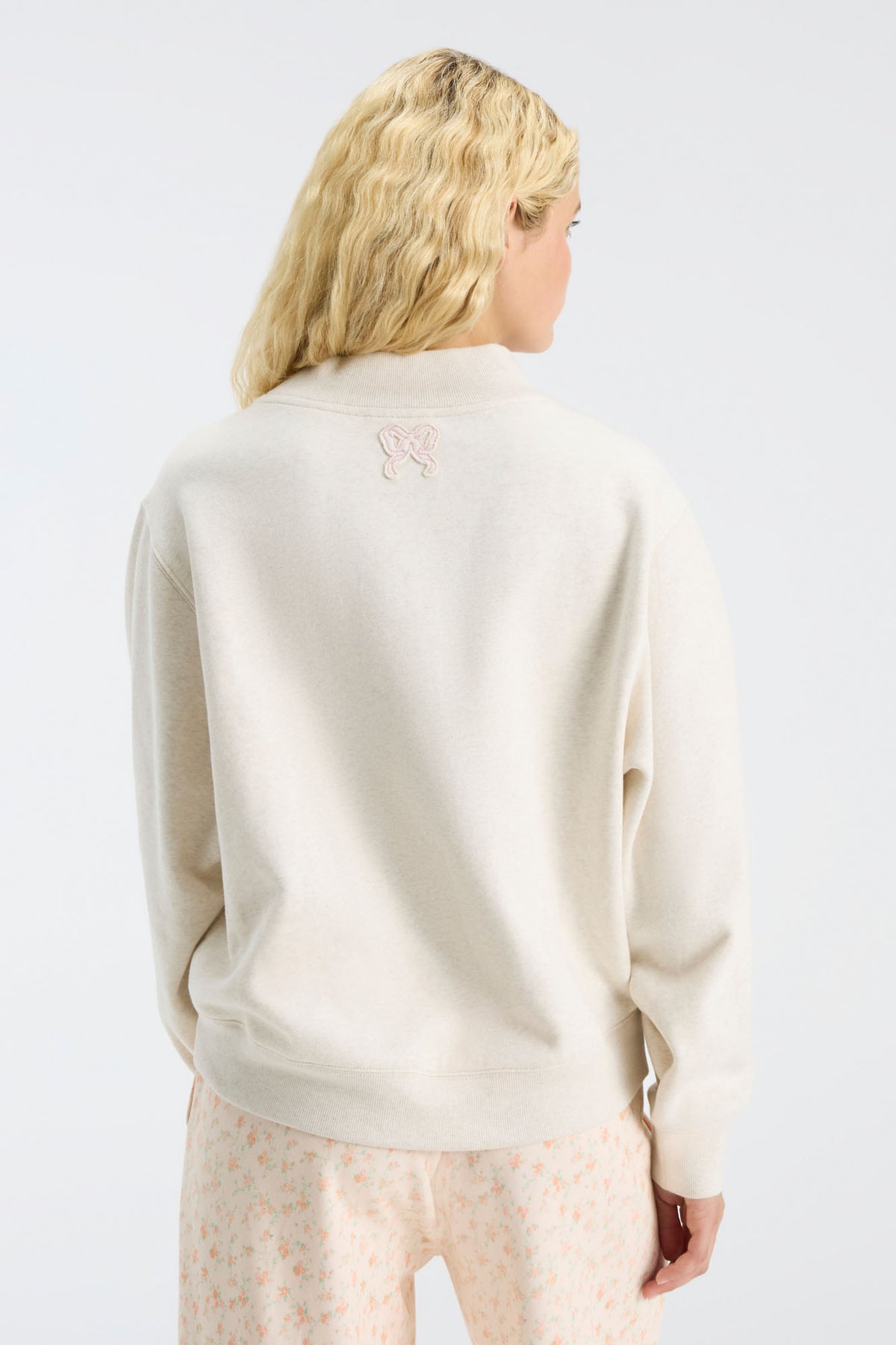Cream mockneck sweatshirt back view with small "LOVE" emblem at center