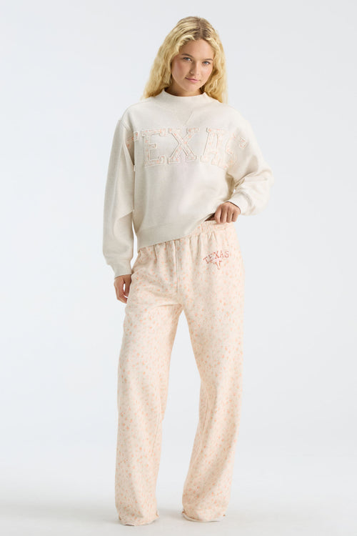Women’s cream sweatpants set with elastic waist, pink drawstring, and Texas-themed floral print