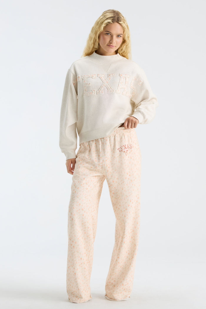 Women’s cream sweatpants set with elastic waist, pink drawstring, and Texas-themed floral print