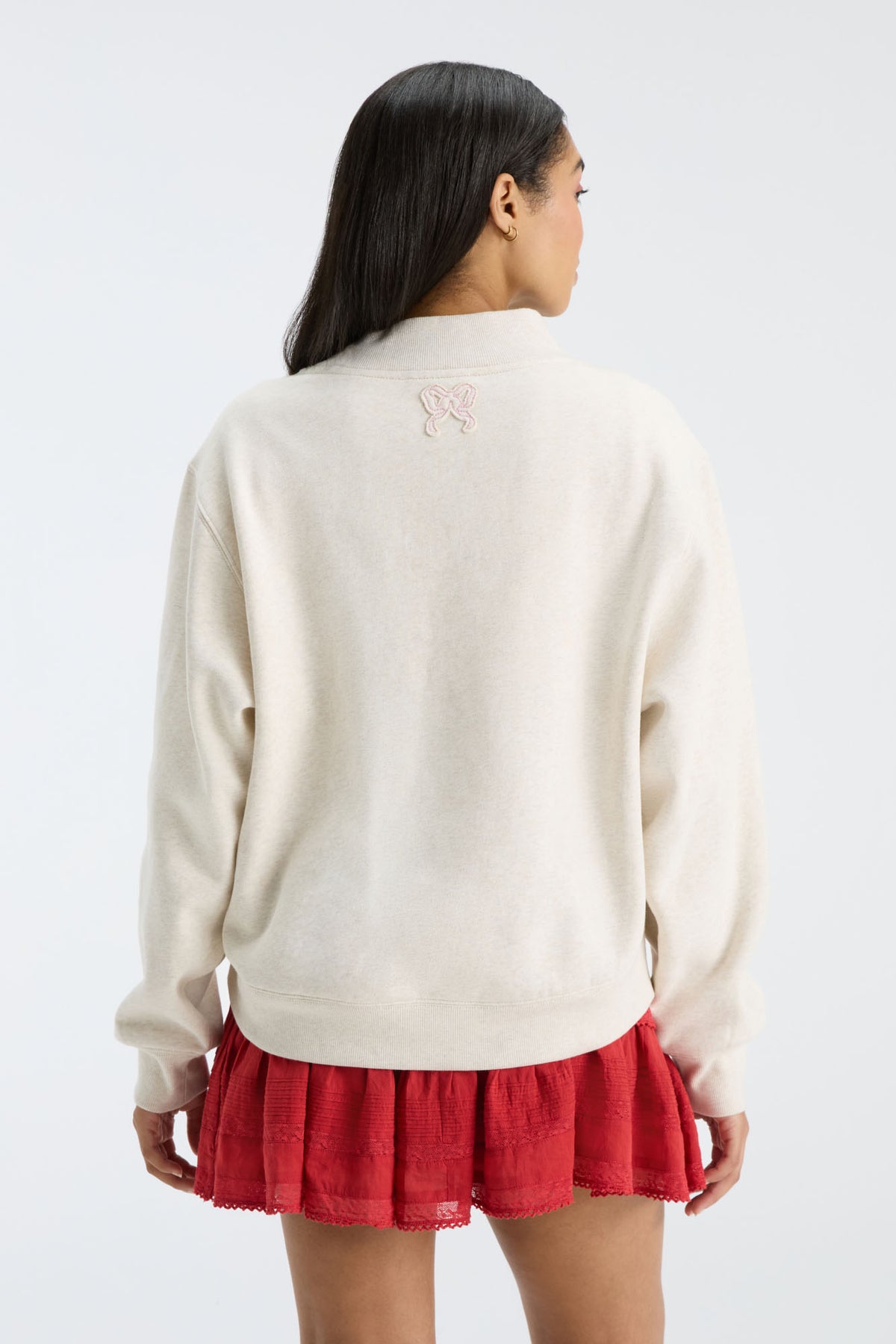 Back view of cream mockneck crew sweatshirt with small logo at upper back