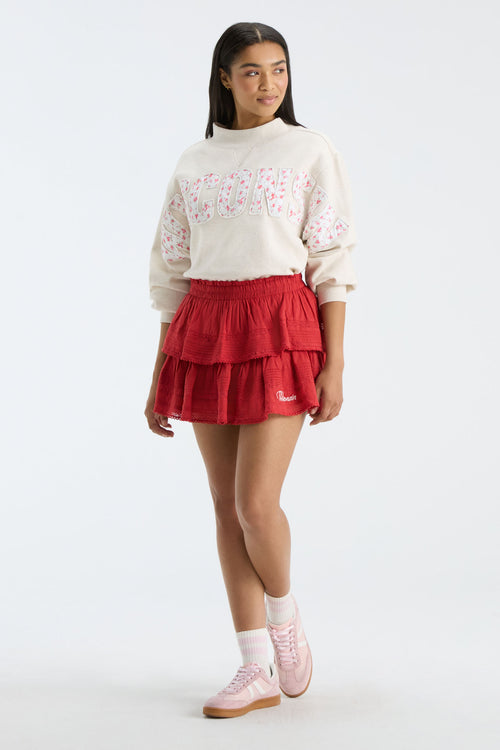 Cream sweatshirt with mock neck, long sleeves, and “FANATICS” floral graphic on front