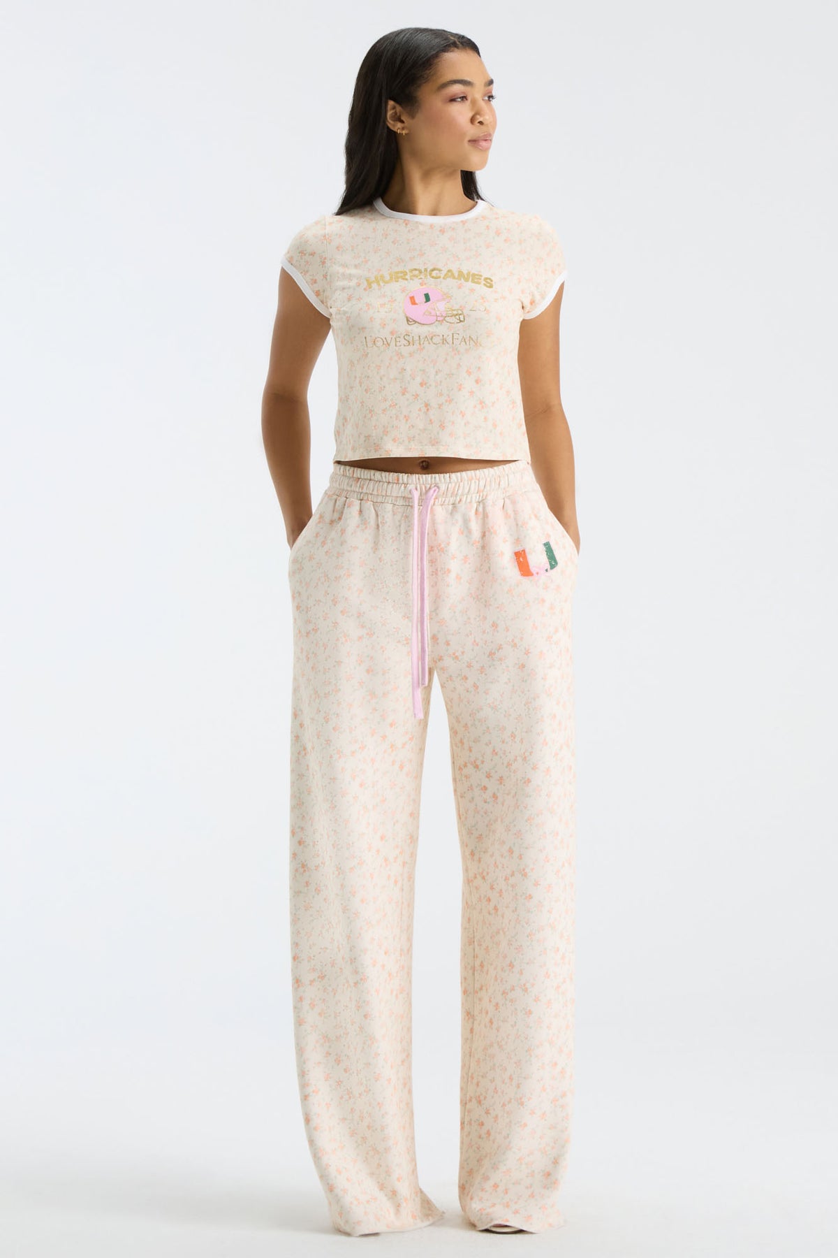 Cream floral-print sweatpants with elastic waistband, drawstring, and wide straight fit